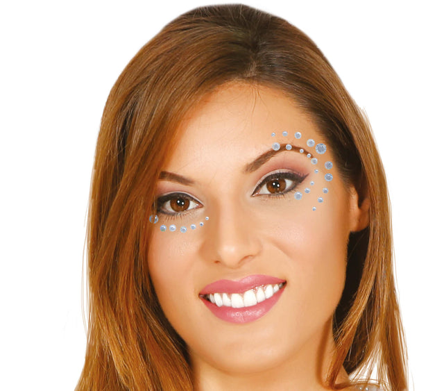Silver and blue adhesive face jewels for women, resin makeup accessories for face decoration and festival looks.