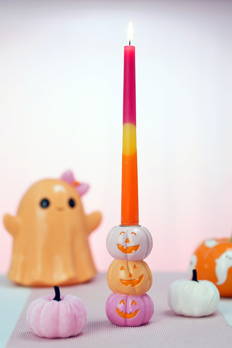 Bougeoir Halloween de trois citrouilles souriantes rose, orange et rose vif portant une bougie bicolore