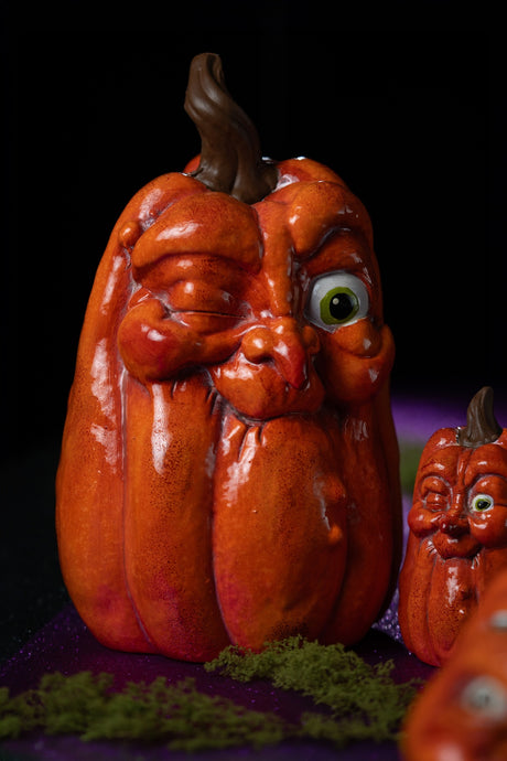 Grande citrouille Halloween allongée à clin d'œil, en scène sur fond sombre pour une décoration d'Halloween