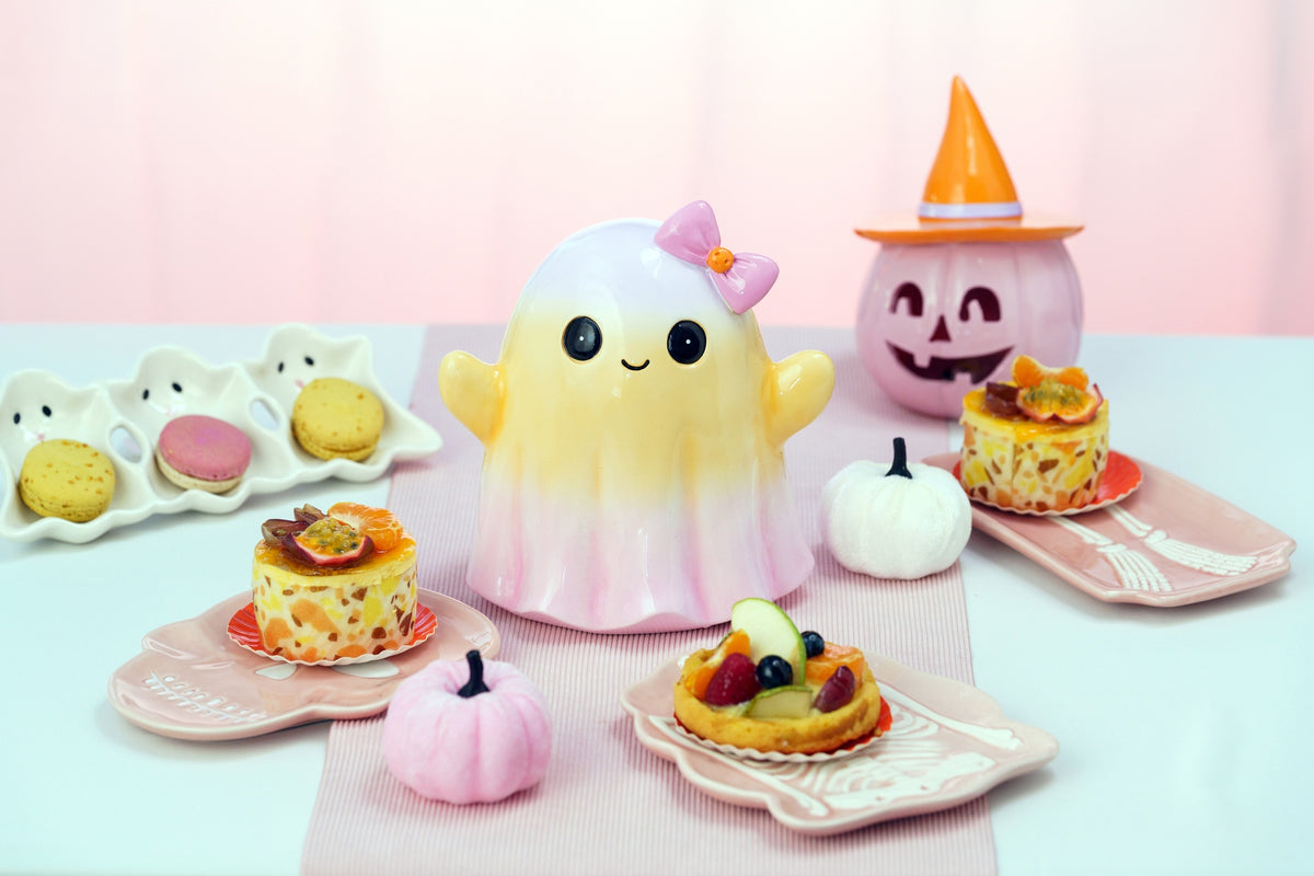 Fantôme Halloween souriant en dégradé jaune et rose à nœud rose, sur une table de goûter d'Halloween