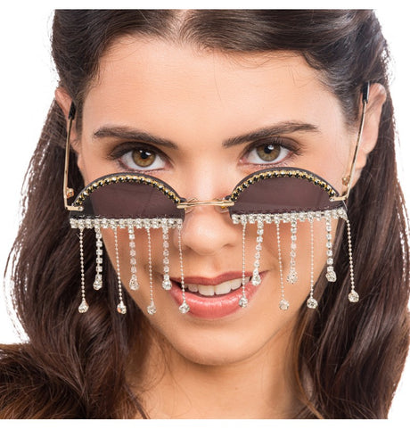 The image shows a pair of festival-themed glasses adorned with rhinestones, designed as a party accessory.