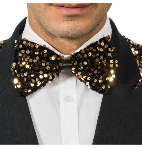 The image shows a black velvet bow tie adorned with bronze sequins, measuring approximately 15cm by 8cm, likely intended as a party accessory.