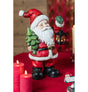 The image shows a decorative Santa Claus figure holding a Christmas tree and a metal lantern, designed as a festive ornament.